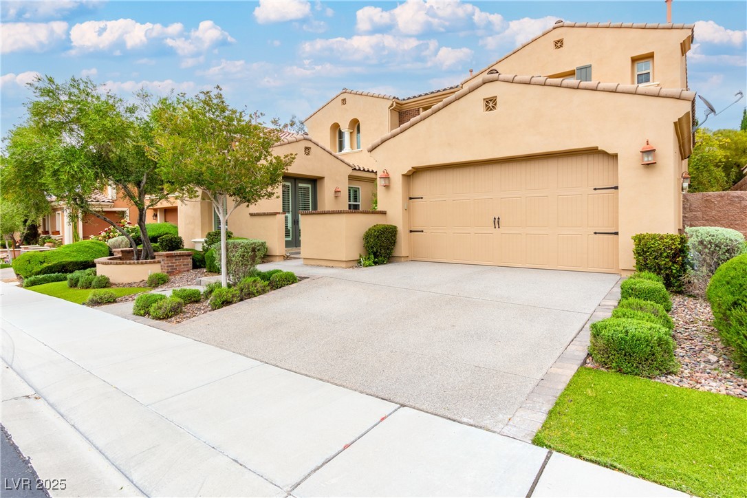 58 Contrada Fiore Drive Henderson, NV 89011 - Photo 5 of 56 Mediterranean / spanish-style house featuring stucco siding, a garage, driveway, and a tile roof