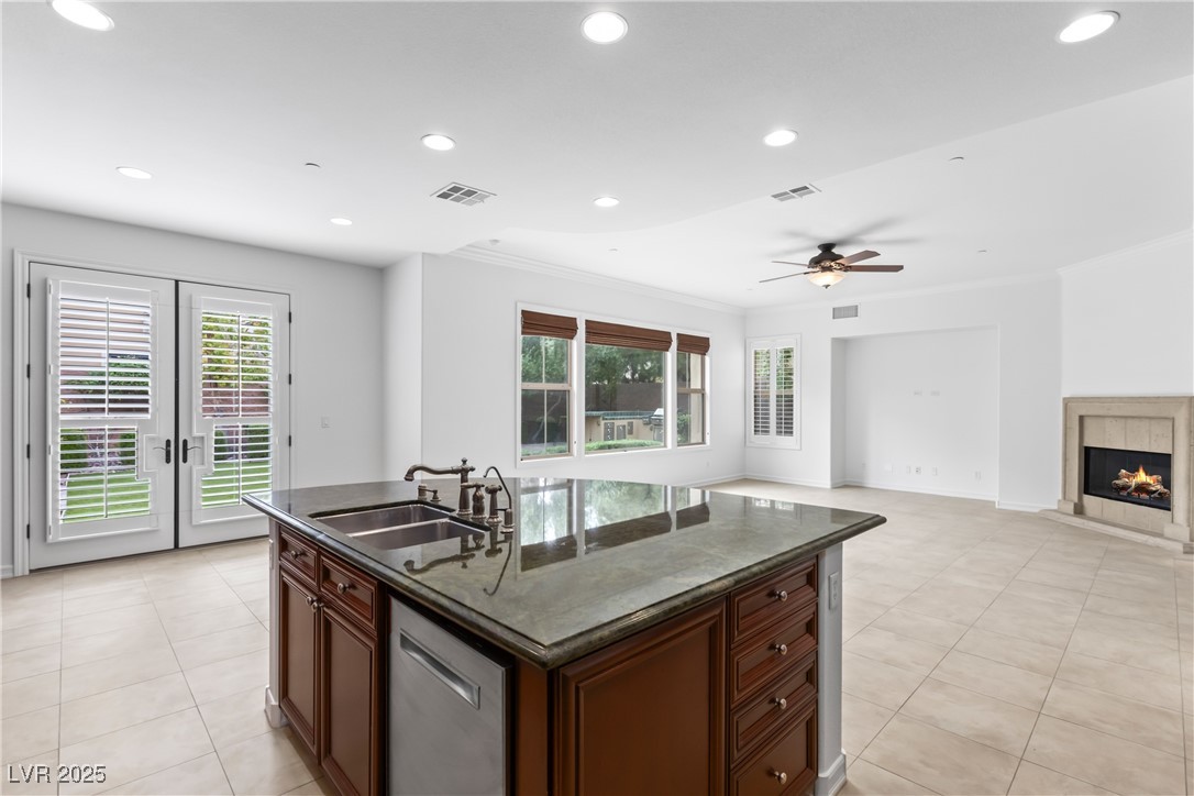 58 Contrada Fiore Drive Henderson, NV 89011 - Photo 10 of 56 Kitchen featuring a center island with sink, recessed lighting, a tiled fireplace, stainless steel dishwasher, and healthy amount of natural light