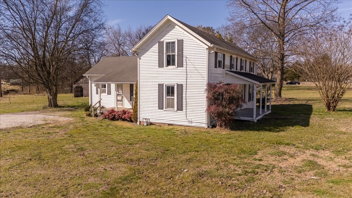 a front view of house with yard and trees in the background