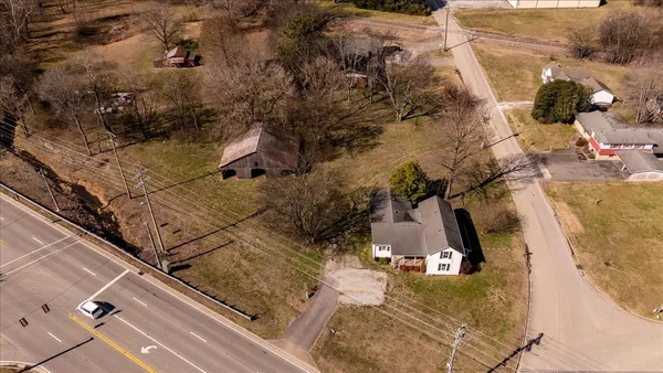 a front view of house with yard and trees in the background