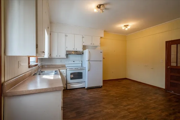 a kitchen with granite countertop a sink a stove and refrigerator