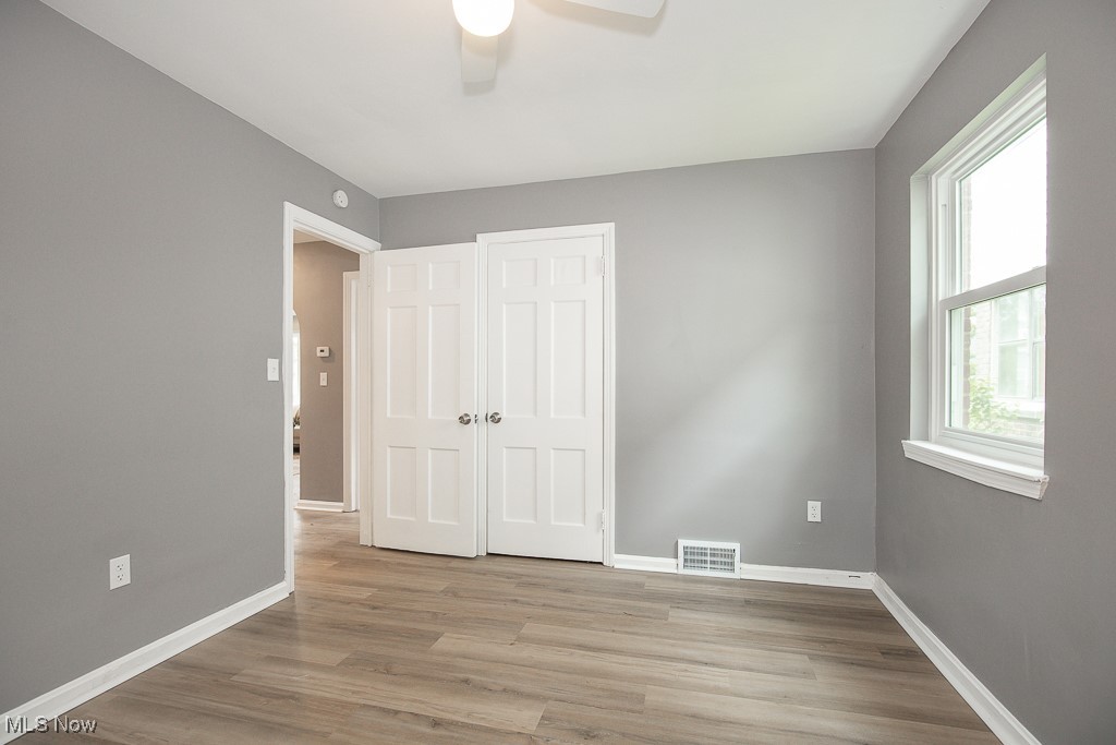 1547 Genesee Road South Euclid, OH 44121 - Photo 11 of 36 Unfurnished bedroom with baseboards, light wood finished floors, a ceiling fan, and a closet