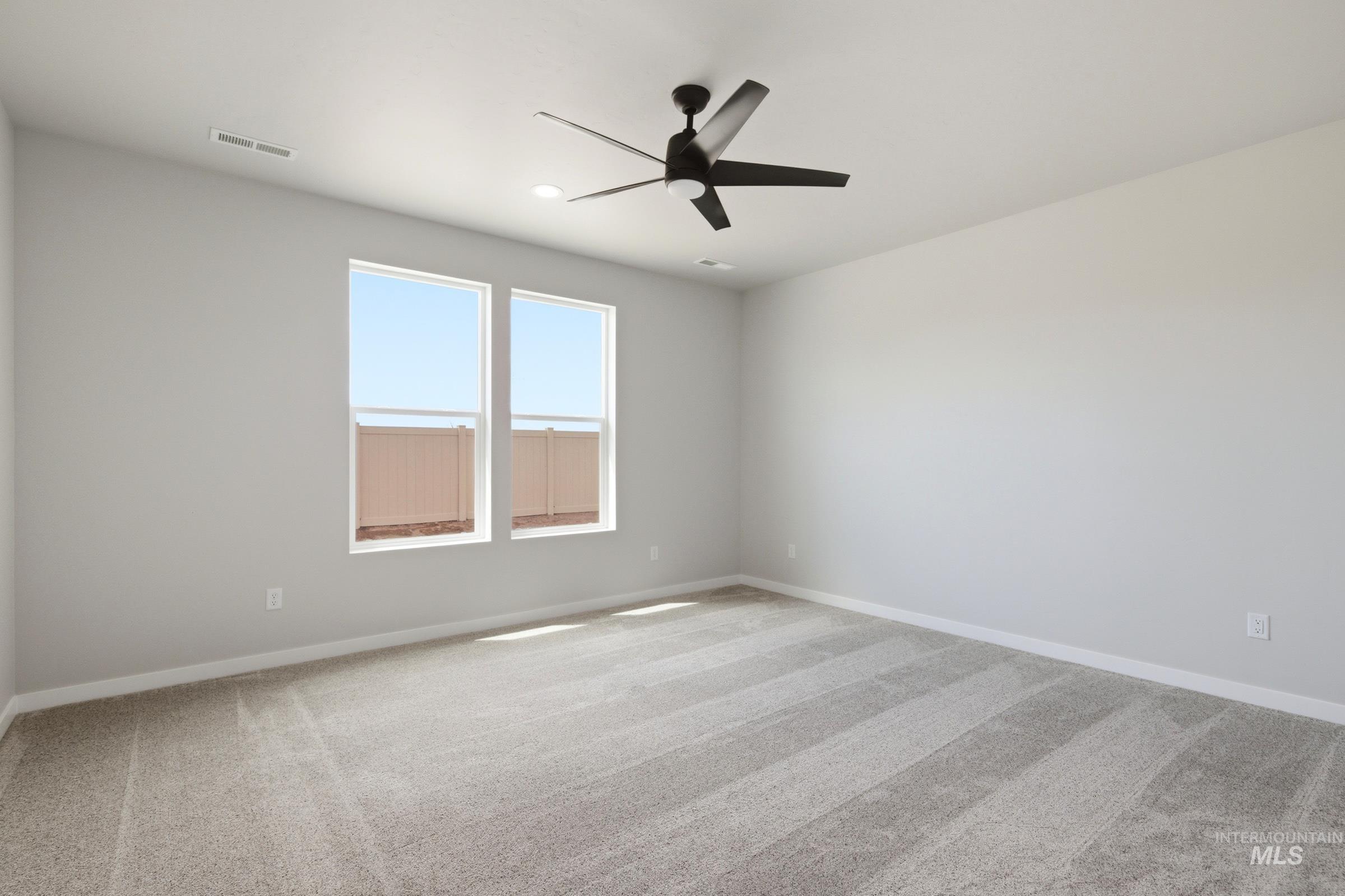 509 Waverly Avenue Middleton, ID 83644 - Photo 17 of 19 Spacious room featuring light gray walls, plush gray carpeting, and a modern black ceiling fan with an integrated light fixture