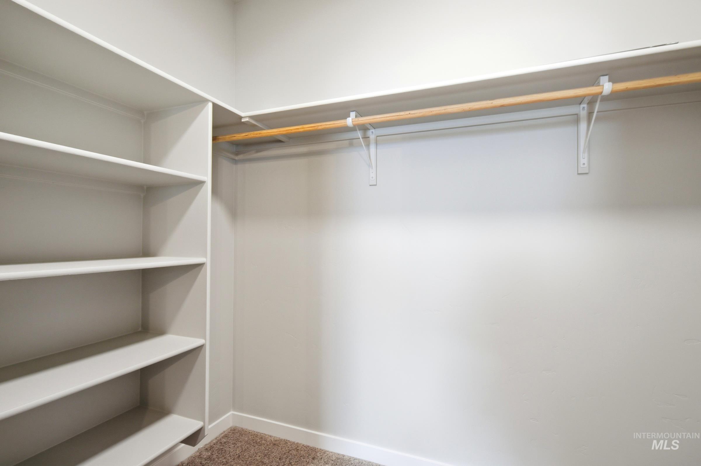 509 Waverly Avenue Middleton, ID 83644 - Photo 18 of 19 Walk-in closet featuring built-in shelving, a full-width hanging rod, and neutral-toned wall paint