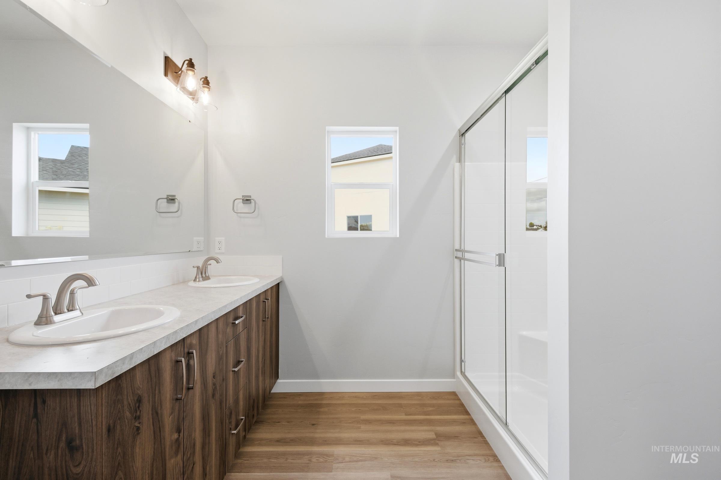 509 Waverly Avenue Middleton, ID 83644 - Photo 19 of 19 Bathroom featuring a double vanity with wood-finish cabinetry, light-toned countertops, and brushed nickel hardware