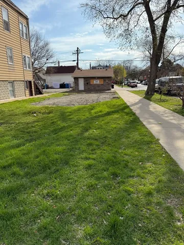 a view of a patio with table and chairs and a large tree