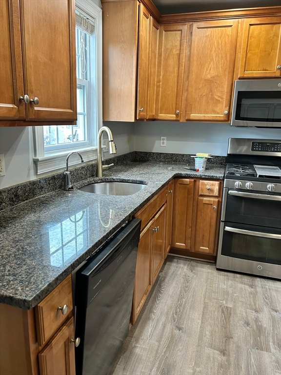 3 Locust Street, Unit 2 Boston, MA 02136 - Photo 1 of 4 a kitchen with stainless steel appliances granite countertop a sink a stove and a microwave