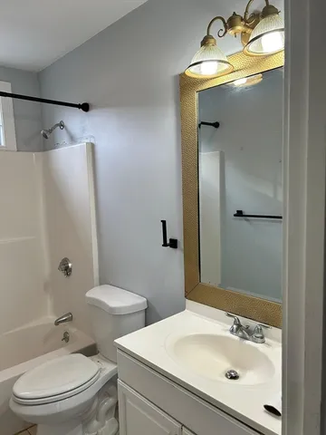 a bathroom with a sink and mirror with toilet