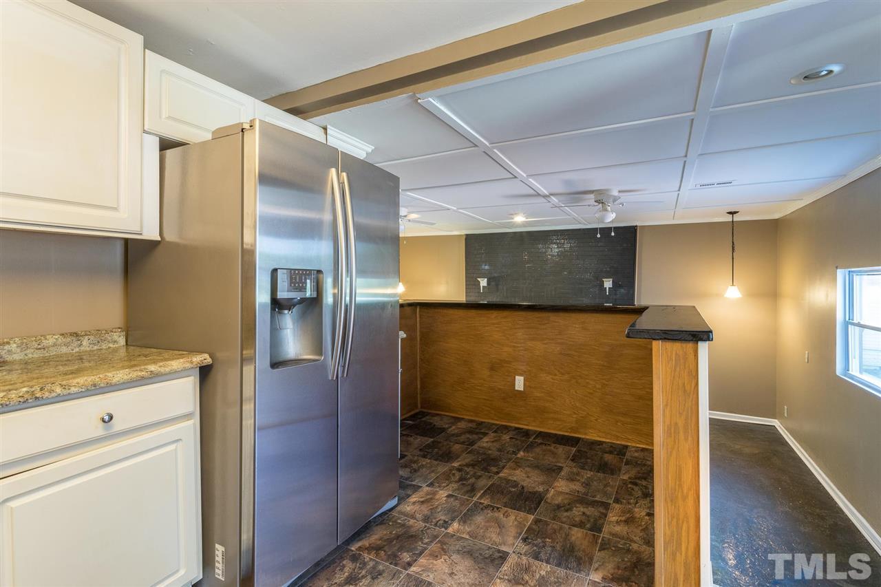 1503 Wiljohn Road Garner, NC 27529 - Photo 9 of 26 a view of a refrigerator in kitchen and an empty room