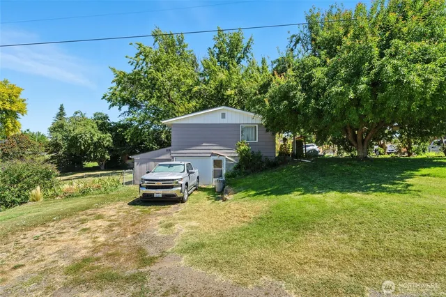 a car parked in front of a house with a big yard
