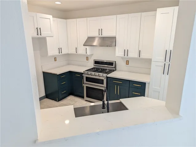 a kitchen with stainless steel appliances a stove a sink and a refrigerator