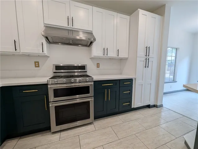 a kitchen with stainless steel appliances granite countertop a stove and a refrigerator