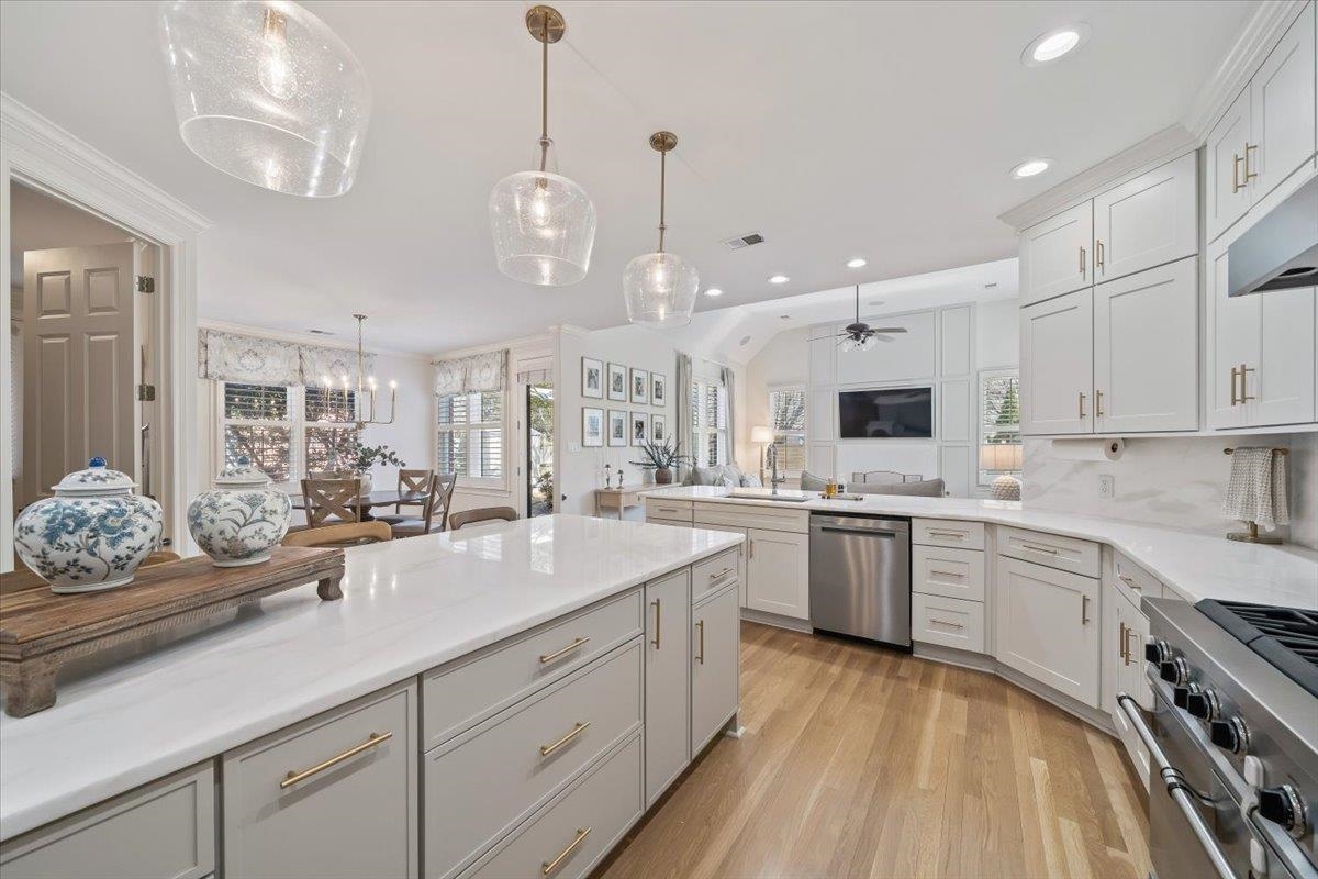 9455 Johnson Rd Extension Germantown, TN 38139 - Photo 14 of 40 Kitchen featuring stainless steel appliances, light wood-type flooring, hanging light fixtures, white cabinetry, and lofted ceiling