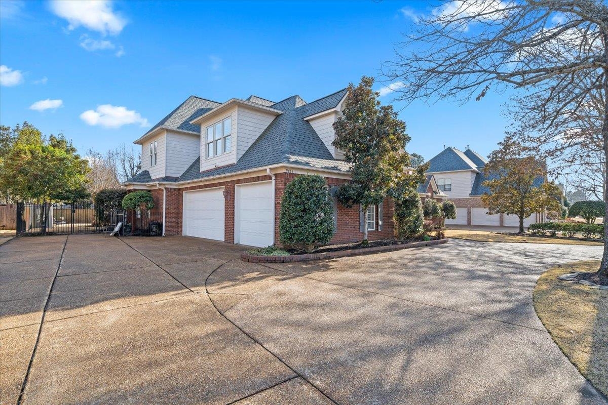 9455 Johnson Rd Extension Germantown, TN 38139 - Photo 2 of 40 View of front of home featuring a shingled roof, driveway, brick siding, and a garage