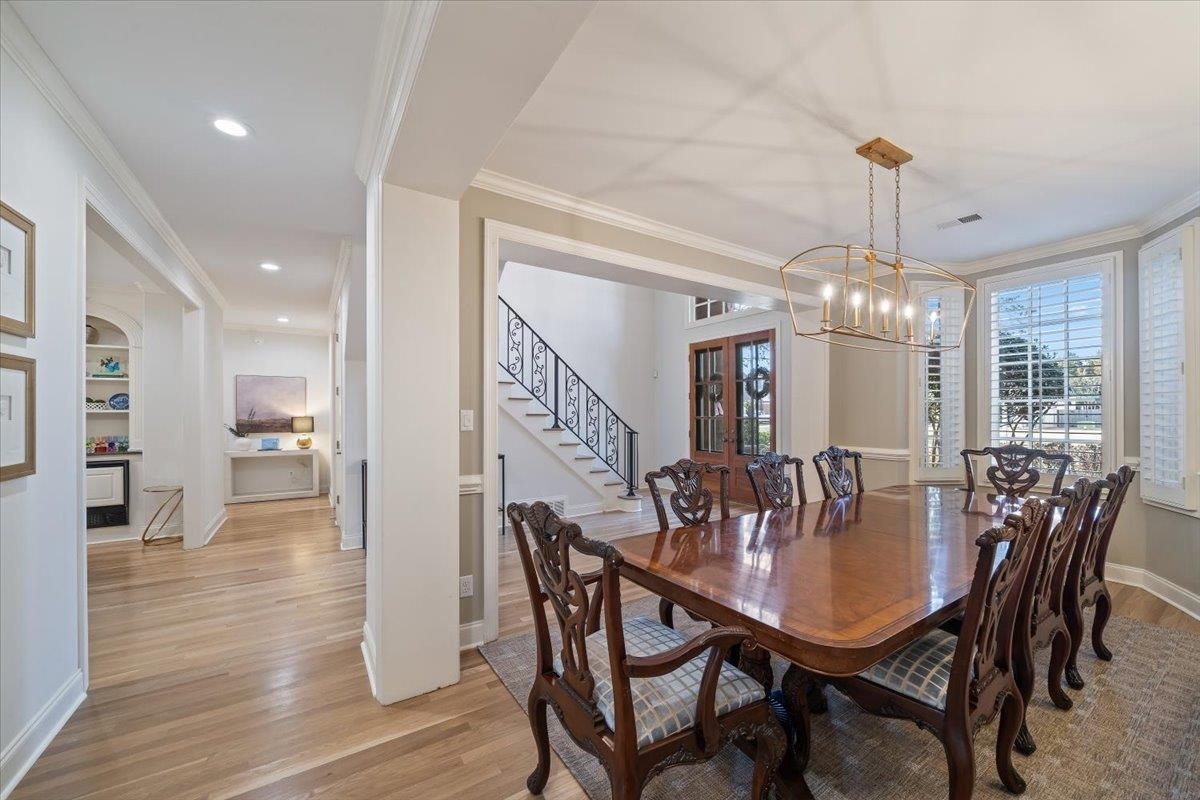 9455 Johnson Rd Extension Germantown, TN 38139 - Photo 8 of 40 Dining space with built in features, light wood finished floors, ornamental molding, and a chandelier