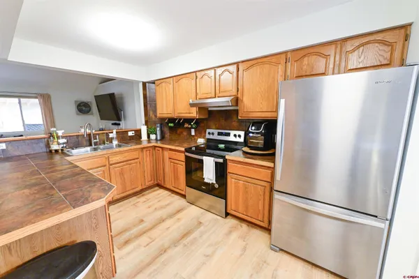 a kitchen with stainless steel appliances a refrigerator sink and microwave