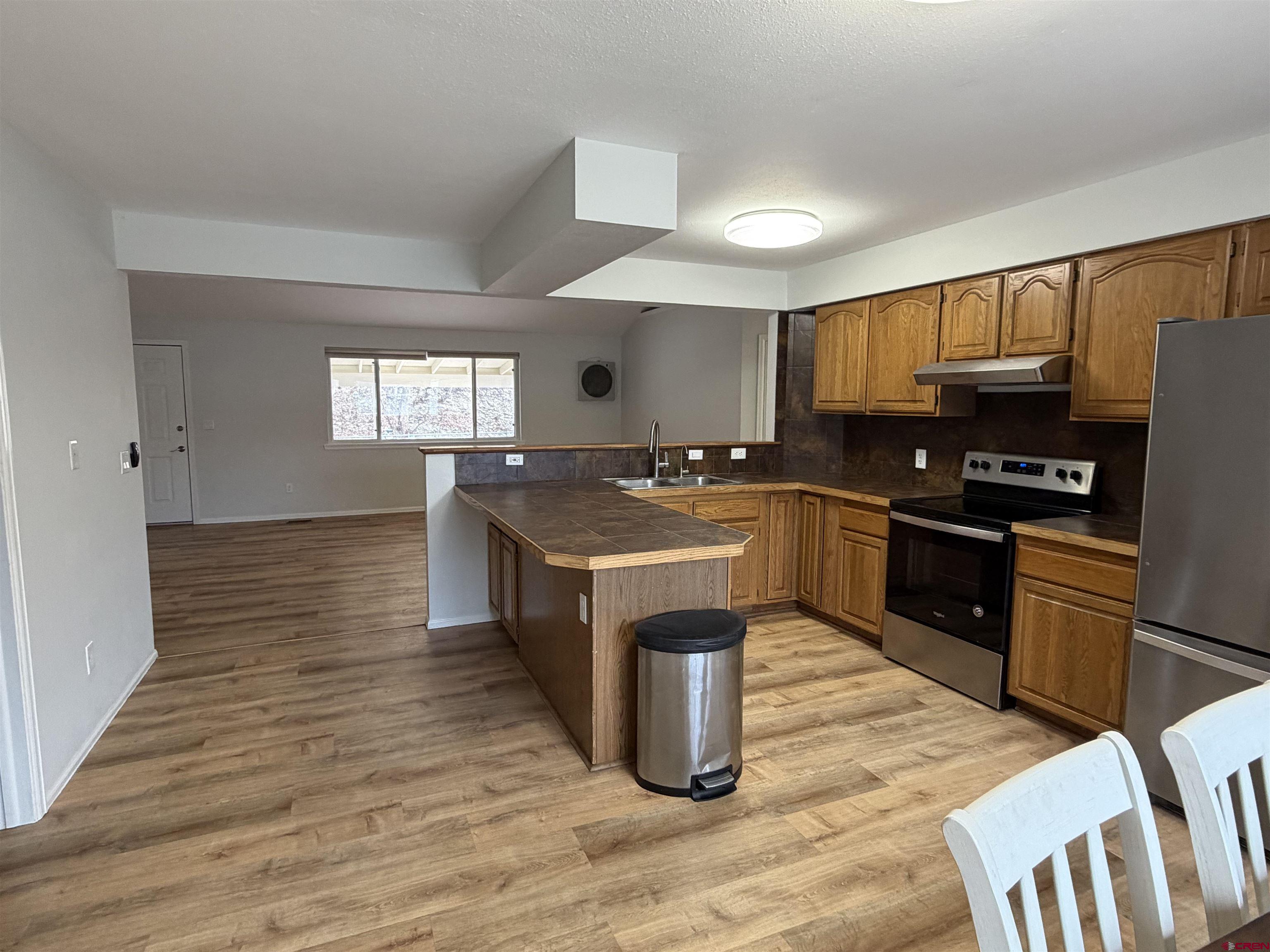 188 Bert Street Delta, CO 81416 - Photo 7 of 36 a kitchen with stainless steel appliances granite countertop a stove a sink dishwasher and a refrigerator with wooden floor