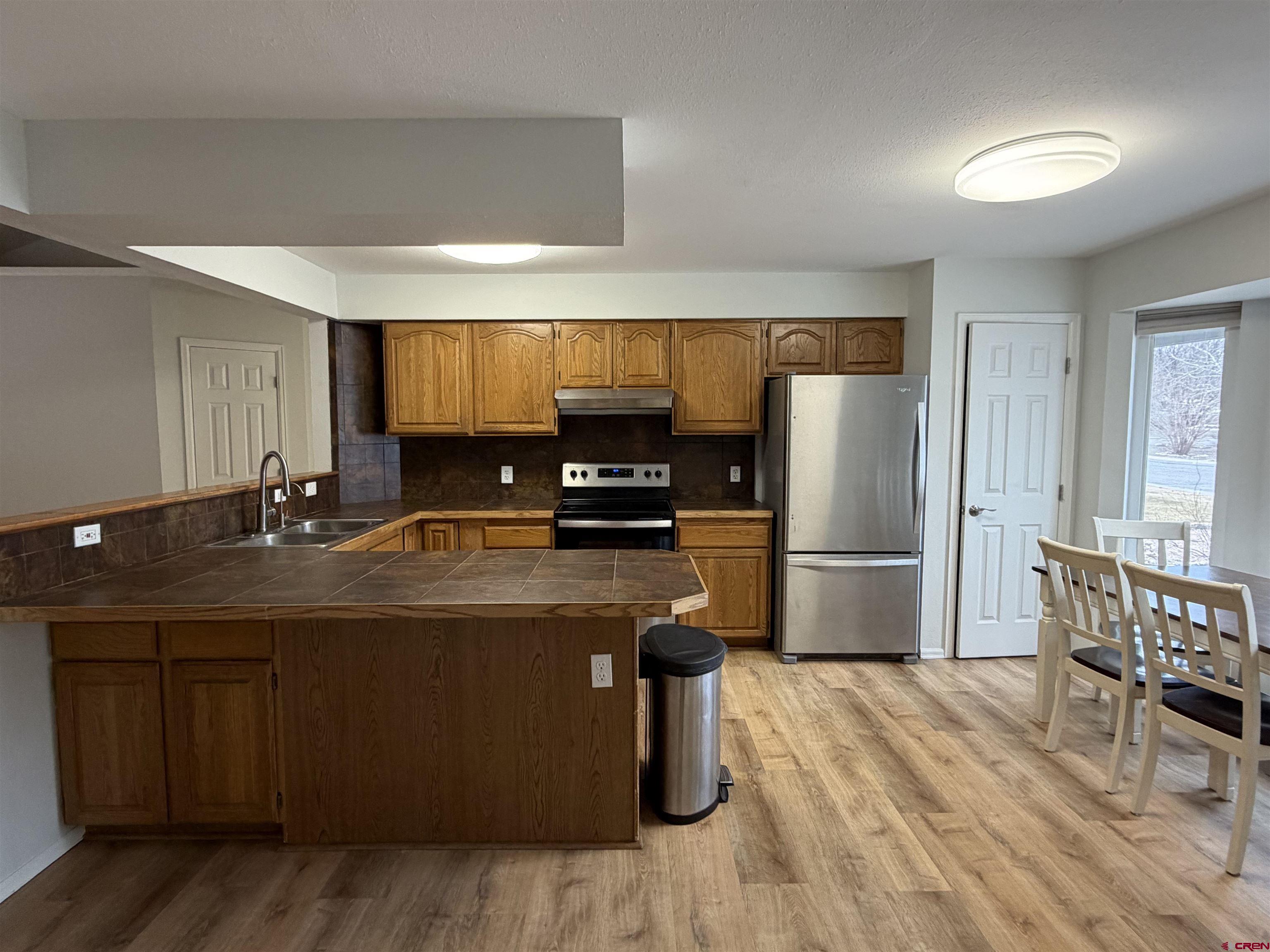 188 Bert Street Delta, CO 81416 - Photo 8 of 36 a kitchen with stainless steel appliances wooden floor sink and refrigerator