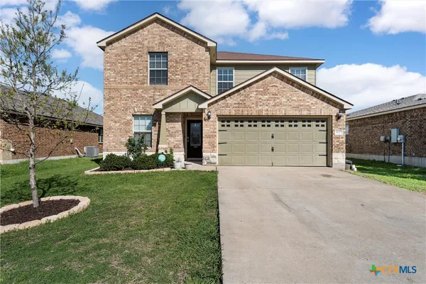 a front view of a house with a yard and garage