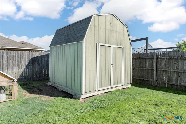 a view of backyard with tub and wooden fence