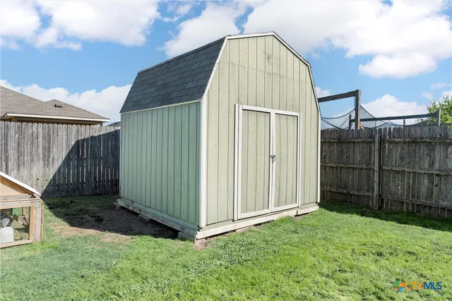 a view of backyard with tub and wooden fence