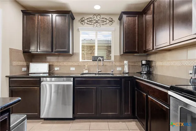 a kitchen with granite countertop cabinets stainless steel appliances and a sink