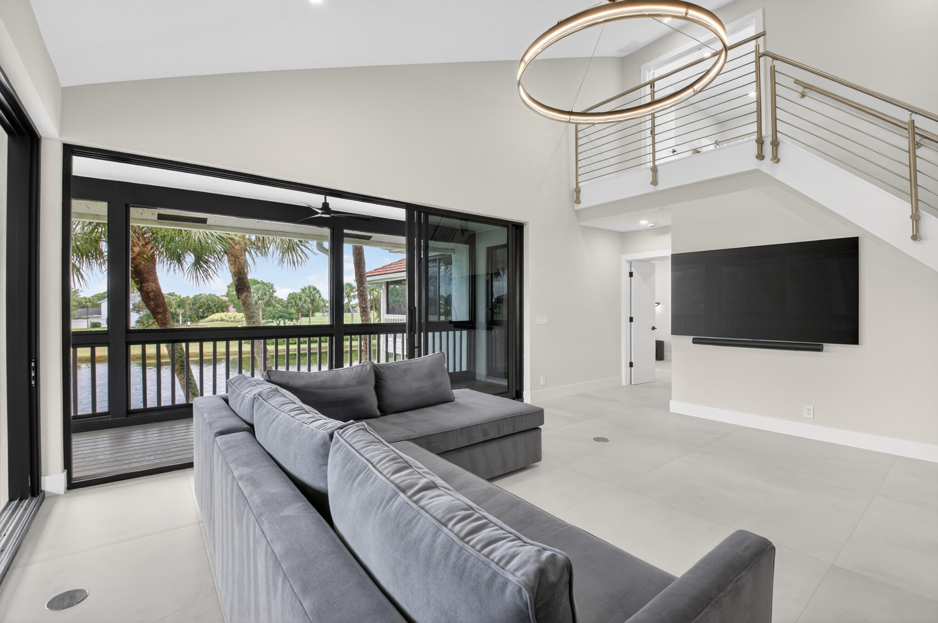 19221 Sabal Lake Drive, Unit 5124 Boca Raton, FL 33434 - Photo 19 of 98 a living room with furniture a flat screen tv and a floor to ceiling window