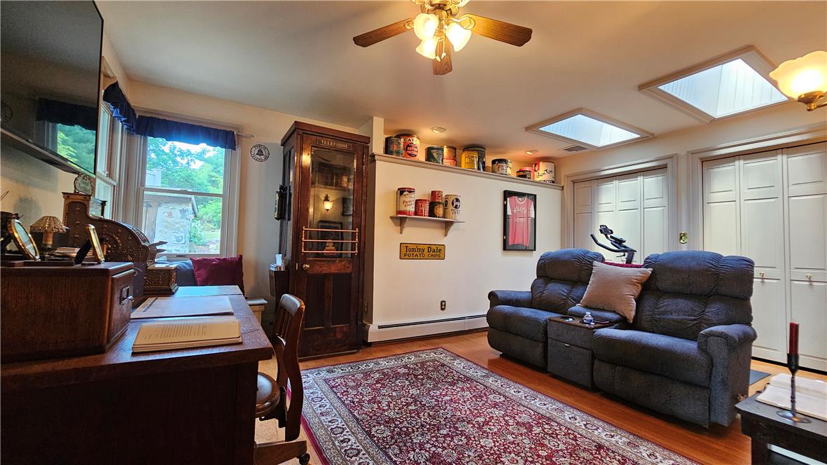 585 Buttermilk Road Hellertown, PA 18055 - Photo 20 of 82 A versatile room featuring skylights and rich hardwood flooring, perfect for work or relaxation.