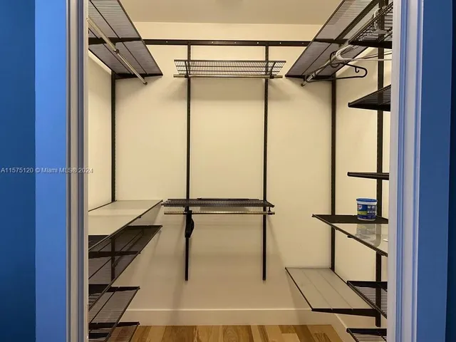 a view of walk in closet with empty racks
