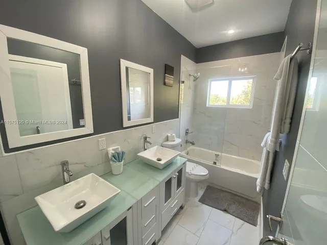 a bathroom with a double vanity sink mirror and toilet