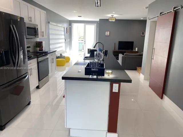 a kitchen with a refrigerator and microwave