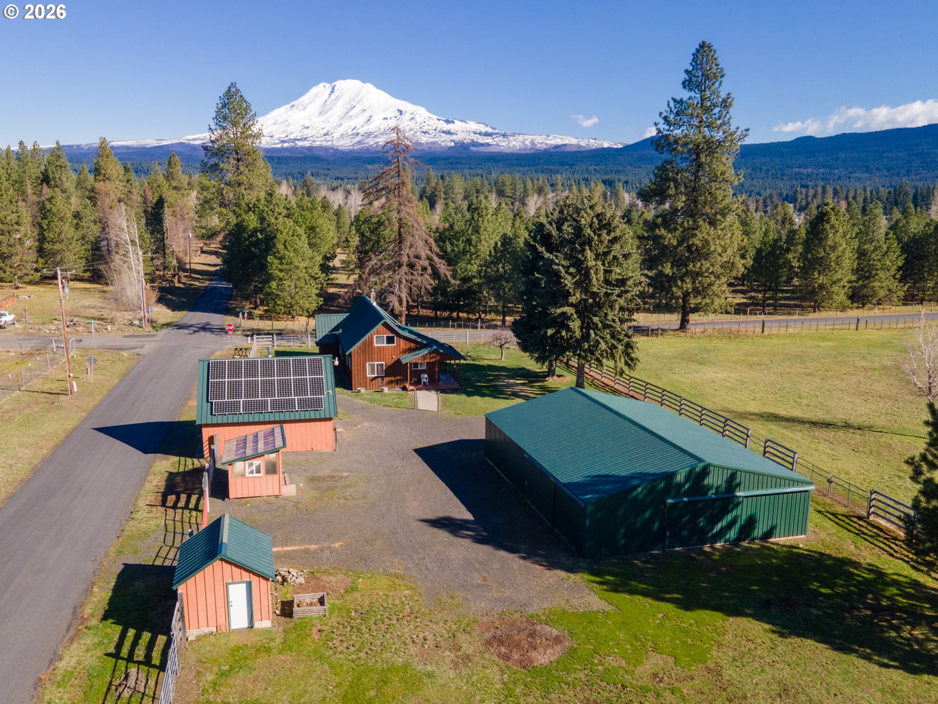 56 Jennings Road Trout Lake, WA 98650 - Photo 1 of 42 a view of a swimming pool with a table and chairs under an umbrella