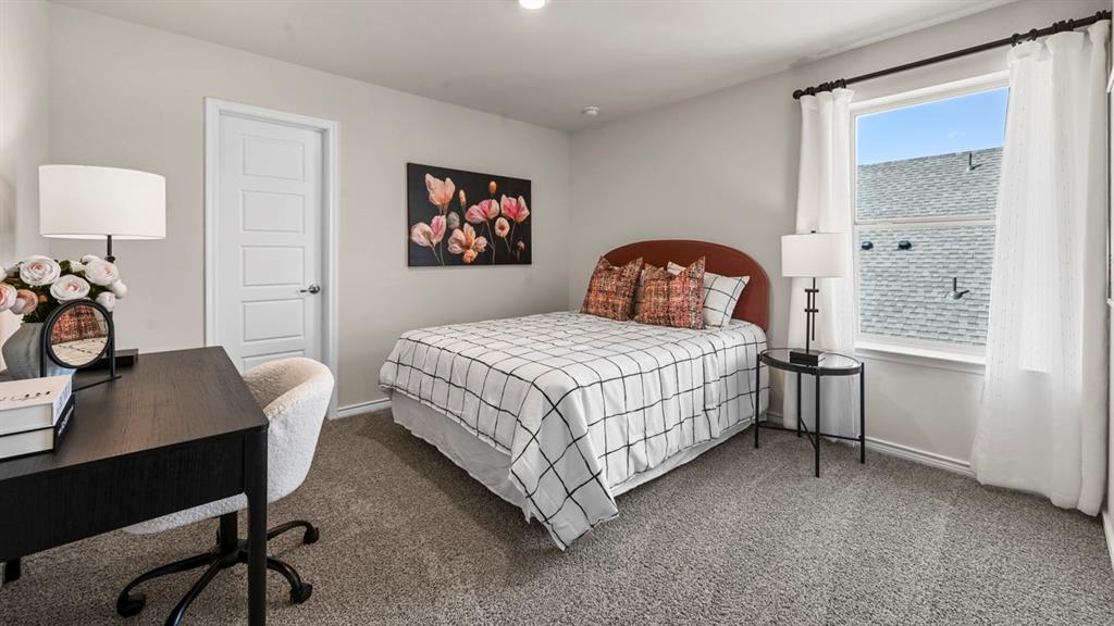 1305 Rusted Rail Drive Princeton, TX 75407 - Photo 8 of 35 a bedroom with a bed and a table in it