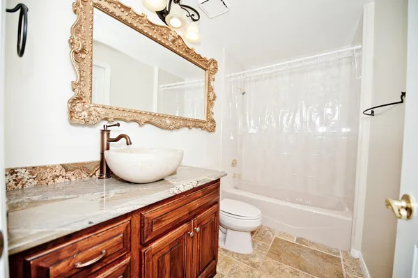 a bathroom with a granite countertop sink and a mirror