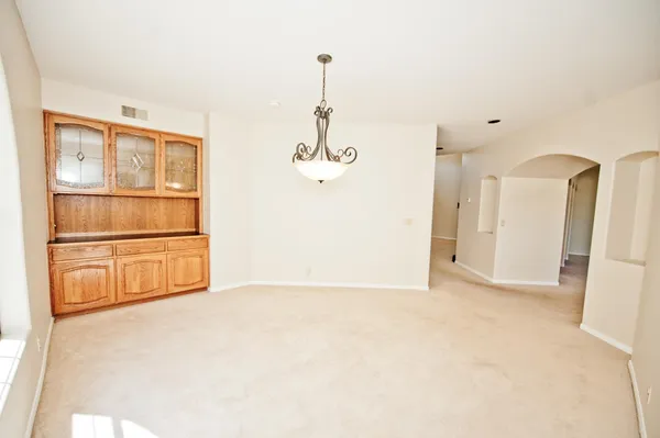an empty room with windows and fireplace