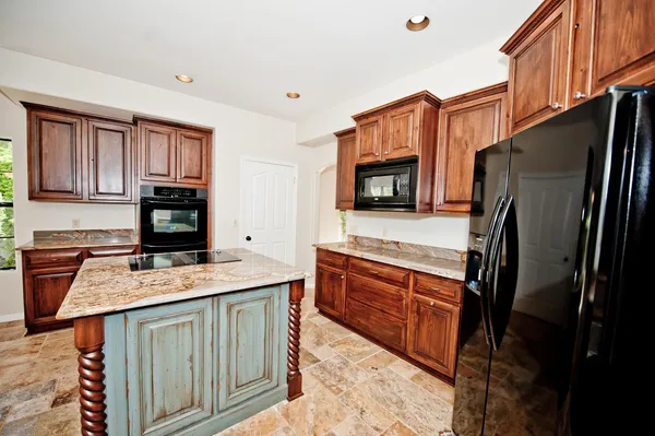 a kitchen with stainless steel appliances granite countertop a refrigerator stove top oven a sink and dishwasher