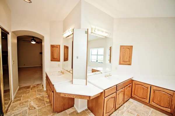 a spacious bathroom with a tub shower and mirror
