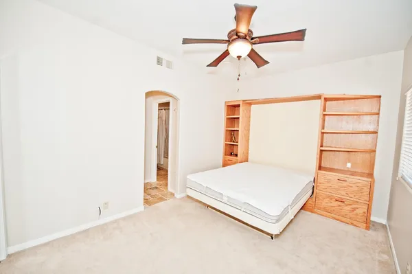 a bedroom with a large bed and a chandelier
