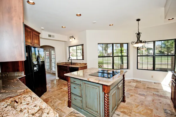 a kitchen that has a lot of cabinets refrigerator and a stove