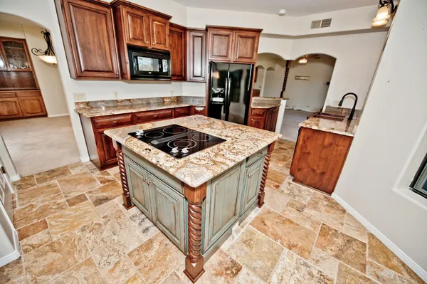 a kitchen with granite countertop a sink stove and refrigerator