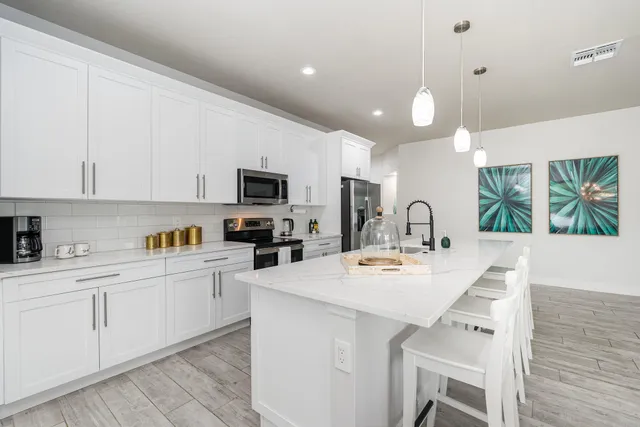 a kitchen with kitchen island granite countertop a sink cabinets and stainless steel appliances