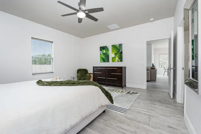 a spacious bedroom with a bed and a dresser