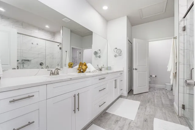 a bathroom with a double vanity sink mirror and shower