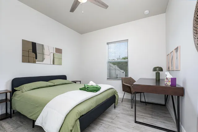 a bedroom with a bed a desk and chair