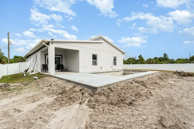 a view of a house with backyard and trees