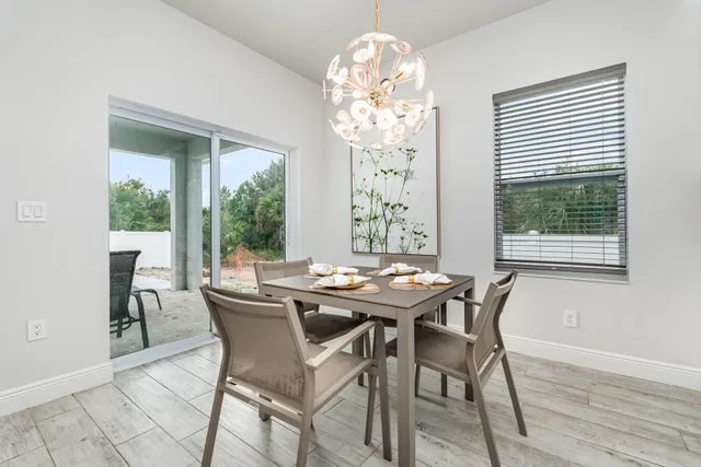 a view of a dining room with furniture a chandelier and wooden floor