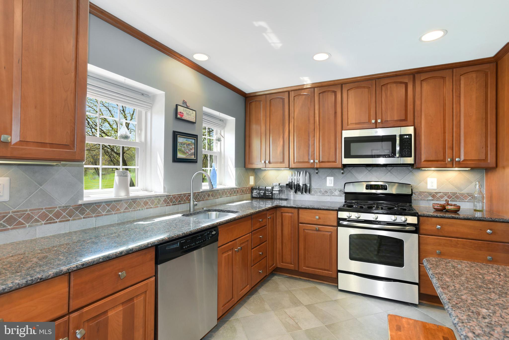 2076 Golf Course Drive Reston, VA 20191 - Photo 8 of 61 a kitchen with stainless steel appliances granite countertop a stove a sink and a microwave