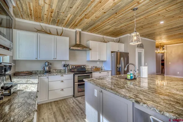 a kitchen with stainless steel appliances granite countertop a sink a stove and cabinets