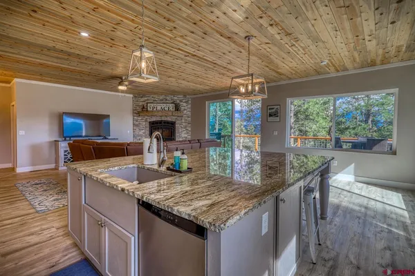 a kitchen with granite countertop kitchen island a large counter space a large window and stainless steel appliances