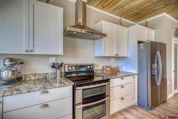 a kitchen with stainless steel appliances granite countertop a refrigerator and a stove